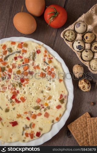 baked omelette dish. baked omelette with different eggs and vegetables with rye small load of bread