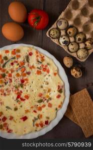 baked omelette with different eggs and vegetables with rye small load of bread. baked omelette