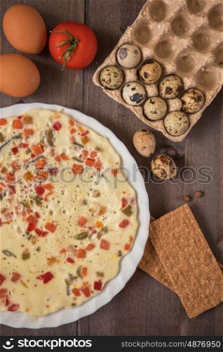 baked omelette with different eggs. baked omelette with different eggs and vegetables with rye small load of bread