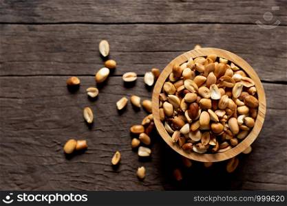 Baked peanuts put in a cup, placed on an old wooden floor.