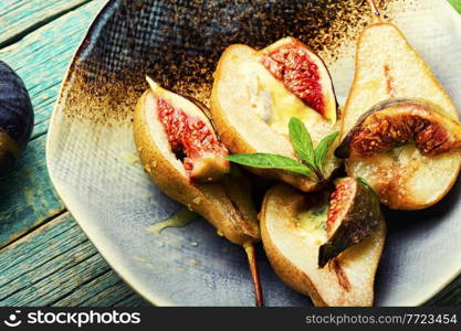 Baked pear halves with figs stuffed with cheese. Baked pear with figs