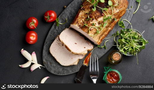 Baked piece of pork balyk on the table with spices. Tenderloin cut into pieces, top view