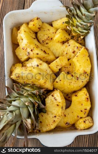 Baked pineapple with chilli flakes in baking pan