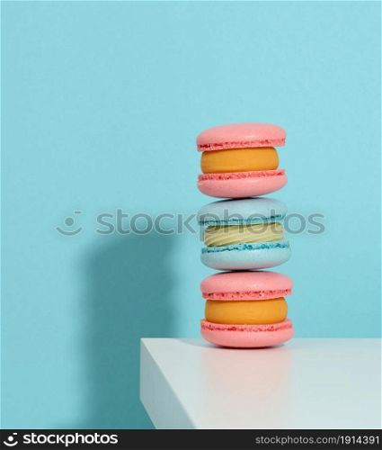 baked pinke round macarons on a blue background, delicious dessert