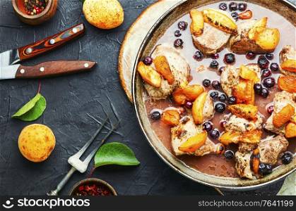 Baked pork in red wine with apricot in iron cast pan. Stew meat with apricot.