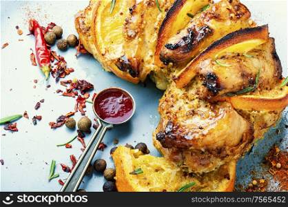 Baked pork meat stuffed with orange and seasonings.Grilled pork with orange.Closeup. Grilled meat with sauce