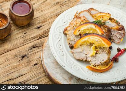 Baked pork meat stuffed with orange and seasonings.Grilled pork with orange fruit. Baked meat in oranges