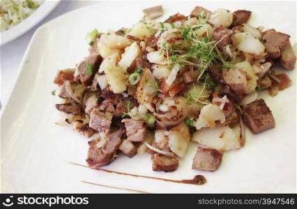 Baked pork meat with grilled onions and potatoes South Tirol and Austrian traditional food.