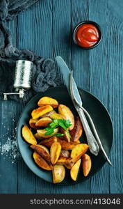 baked potato and tomato sauce, potato on black plate