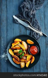 baked potato and tomato sauce, potato on black plate