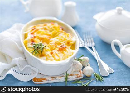 Baked potato gratin with garlic, cream and cheese, traditional french cuisine. White background