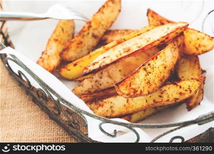Baked potato wedges on basket - homemade organic vegetable, vegan potato wedges snack food meal