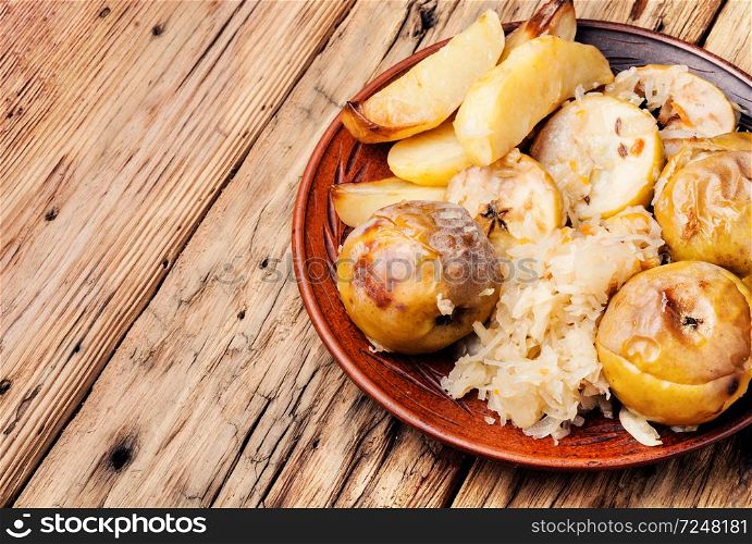 Baked potato with apples and sauerkraut.Rustic food. Baked potatoes, apples and sauerkraut.