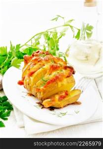 Baked potatoes layered with smoked bacon and cheese in a plate on a towel against light wooden board background