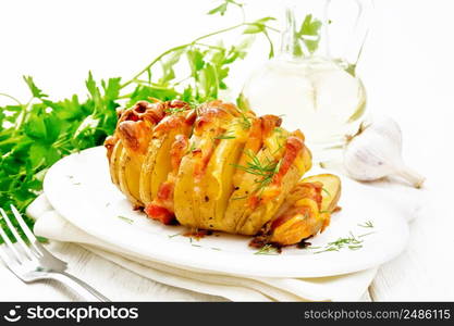 Baked potatoes layered with smoked bacon and cheese in a plate on a napkin against light wooden board background