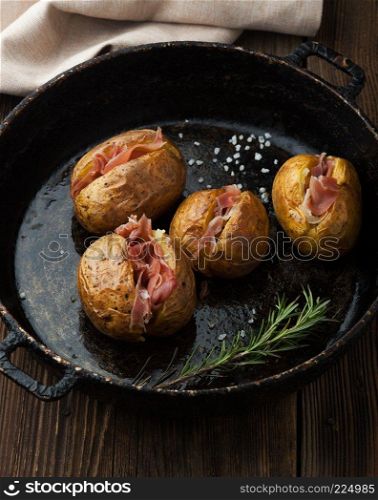 Baked potatoes with prosciutto and cheese in a pan