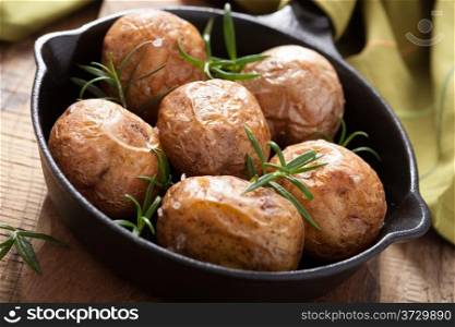 baked potatoes with rosemary in black pan