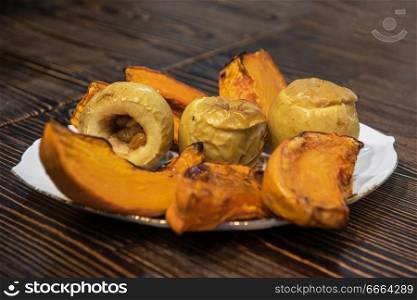 Baked pumpkin and apples on plate. Baked pumpkin and apples