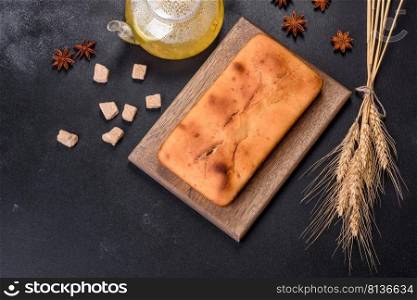 Baked rectangular cupcake with raisins and chocolate on a dark concrete background. Homemade delicious pastries. Baked rectangular cupcake with raisins and chocolate on a dark concrete background