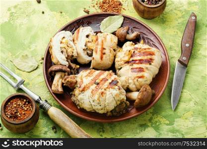 Baked rolled chicken meat with mushrooms on plate. Chicken roll with mushrooms