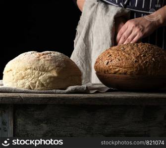 baked round bread on a wooden table, dark background