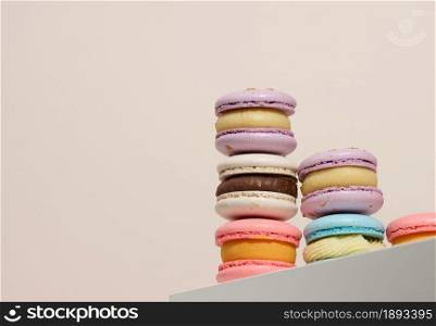 baked round macarons on a beige background, delicious dessert, bottom view