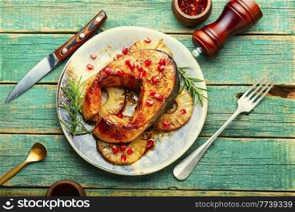 Baked salmon steak with pineapple on wooden table. Delicious baked salmon with pineapple