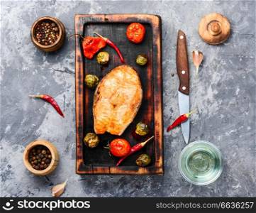 Baked salmon with tomato, pepper and cabbage.Fish steak with vegetable garnish.Fish for healthy dinner. Baked salmon steak