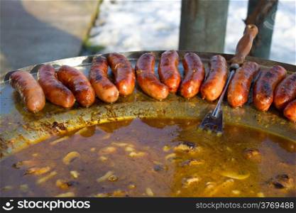 Baked sausages in traditional croatian dish kotlovina