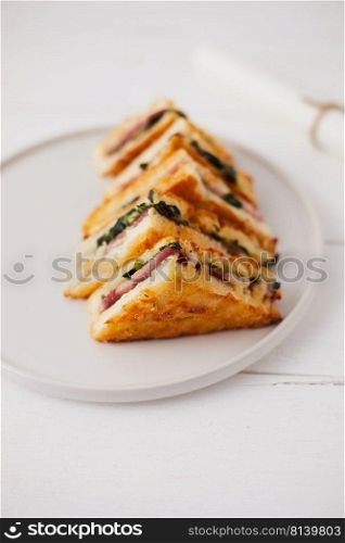 Baked spinach and ham sandwich with sauce.