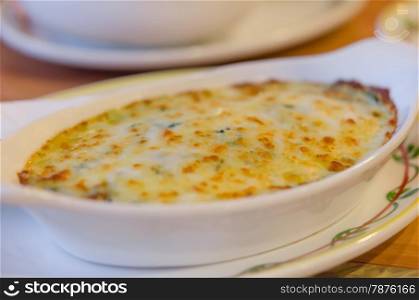 Baked spinach with cheese . close up Baked spinach with cheese in white bowl