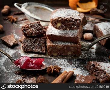 baked square pieces of chocolate brownie sprinkled with powdered sugar on the table