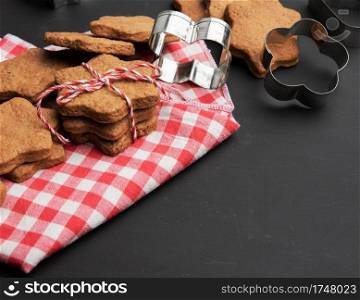 baked star shaped gingerbread cookies on black table, christmas baked goods
