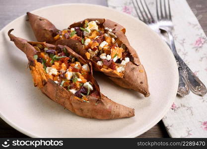 Baked sweet potato stuffed with chopped sun-dried tomatoes, olives, feta cheese and basil with aromatic dressing