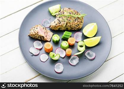Baked tuna steak with vegetable garnish.Fish cooked with vegetables.. Grilled tuna steak