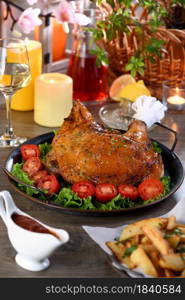 Baked turkey drumstick on a vegetable tray on a festive dinner table in honor of Thanksgiving.