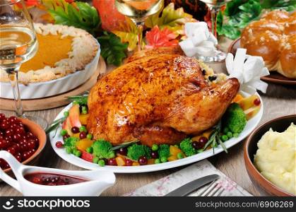 Baked turkey with vegetables, pumpkin pie, mashed potatoes, garlic buns andcranberry-orange sauce on the table dinner on Thanksgiving Day