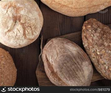 baked various breads on wooden background, top view