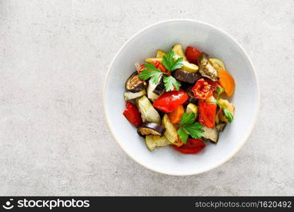 Baked vegetables salad with fresh parsley. Top view