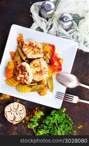 baked vegetables with cutlet. baked vegetables with cutlet on white plate
