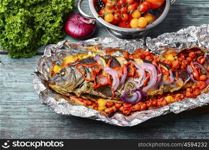 Baked whole fish. Mackerel baked in tomatoes and spices on the kitchen table