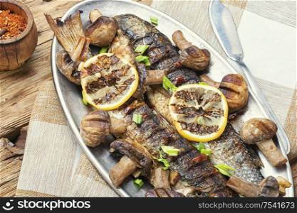 Baked whole pelengas fish with mushrooms and lemon.Sea food.Grilled fish with mushrooms.. Delicious roasted fish