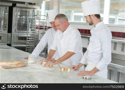 baker and assistants in a bakery kitchen