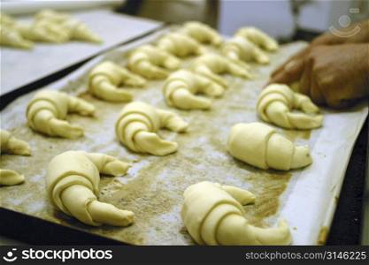 Baker making croissants