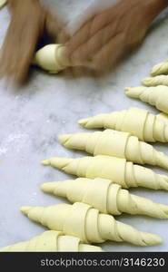 Baker making croissants