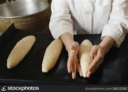 Baker Shaping Loaves of Bread Dough