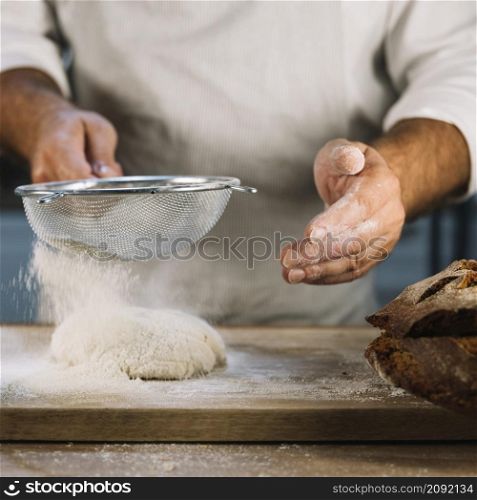 baker sifting wheat flour through steel sieve knead dough