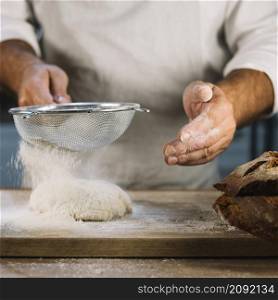 baker sifting wheat flour through steel sieve knead dough