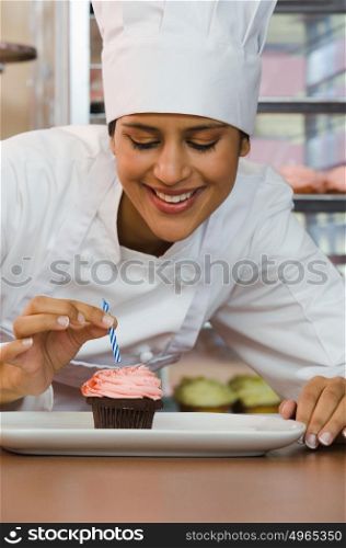Baker with cupcake and candle