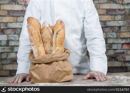 baker with traditional bread french baguettes